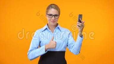 高加索商贸女士伸出拇指，手握智能手机，应用程序